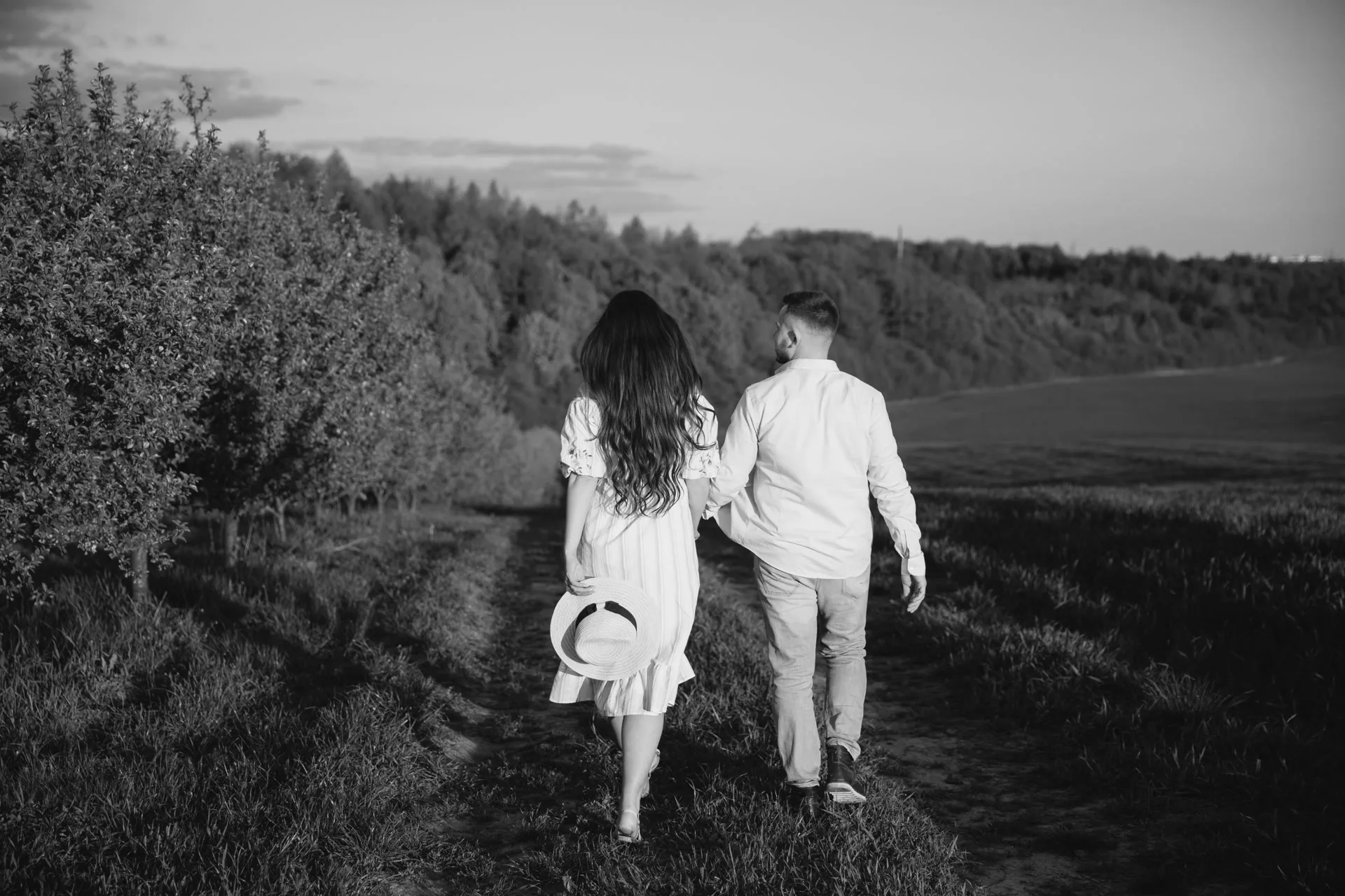 Couple walking through a forest path, holding hands